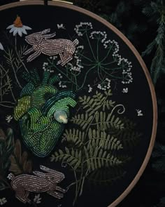 a close up of a embroidery on a black background with plants and animals in it