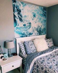 a bedroom with blue and white decor on the wall above the bed is decorated with an ocean theme