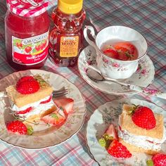 strawberry shortcakes with whipped cream and strawberries are on plates next to jam