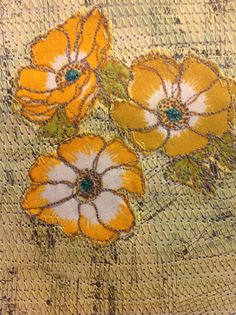 some yellow and white flowers are on a piece of cloth with wire work in the background