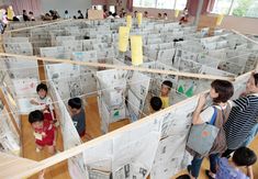 several children are looking at newspapers on display