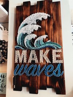 a wooden sign that says make waves on the front and back with beaded words