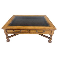 a wooden table with two drawers on one side and a leather top on the other