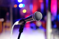 a microphone that is sitting in front of a mic on a stand with blurry lights behind it