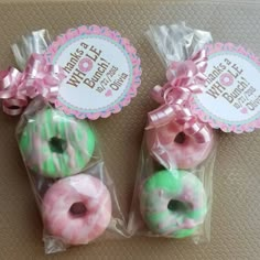 two packaged donuts with pink and green frosting