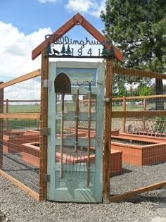 an outdoor garden area with several raised beds and a wooden structure that has a sign on top