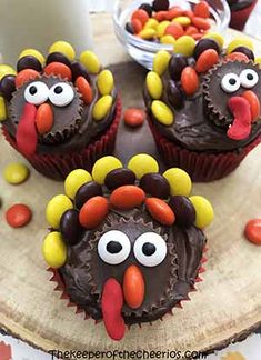 cupcakes with chocolate frosting decorated to look like turkeys and candy eyes