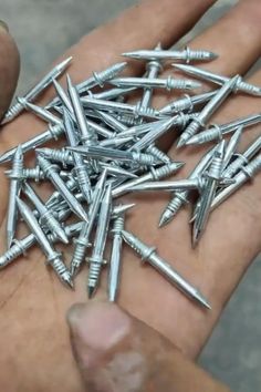 a person holding a bunch of nails in their hand