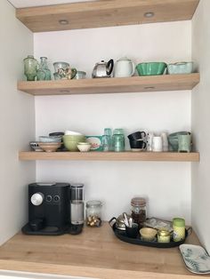 the shelves are filled with dishes and cups