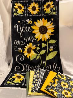 sunflowers and bees are on the back of a black bag with yellow accents