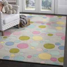 a white rug with multicolored polka dots on it in front of a door