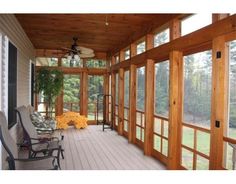 a porch with lots of windows and chairs