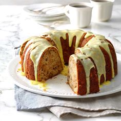 a bundt cake on a white plate with lemon glaze drizzled over it