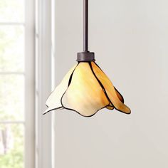 a light fixture hanging from the ceiling in a room with white walls and windows behind it