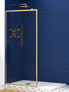 a bathroom with blue walls and white flooring, gold trimming on the shower