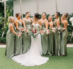 a group of women standing next to each other on top of a lush green field