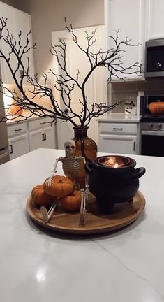 a white kitchen counter top with a black bowl and some pumpkins on the plate