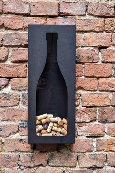 a wine bottle mounted to the side of a brick wall with corks in it