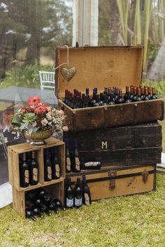 an old trunk is filled with bottles of wine and other things to be used for wedding decor