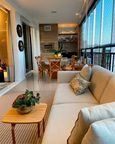 a living room filled with furniture and lots of windows next to a dining room table