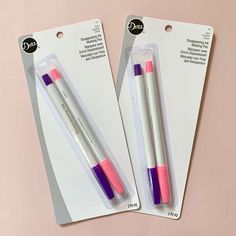 two pink and purple pens sitting next to each other