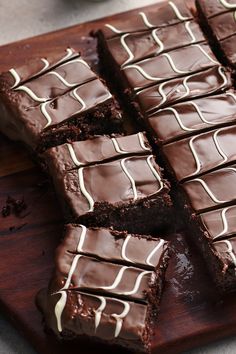 chocolate brownies with white icing on a cutting board