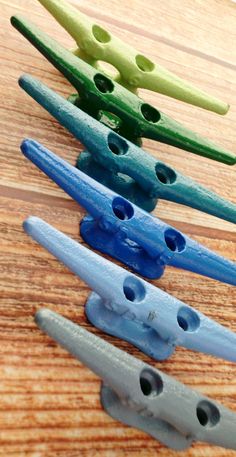 five different colored toothbrushes lined up on a wooden surface with holes in them