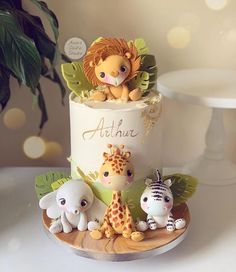 a three tiered cake decorated with animals and plants