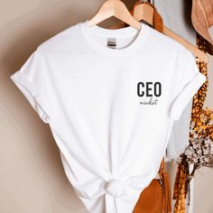 Manifest your CEO Mindset with this trendy tee.  Let everyone know you are the Boss Babe that you werent to be. This unisex tee is soft and super Cute! This cute CEO Mindset shirt goes great with leggings - tied up in a knot or tucked in with your favorite pair of jeans and heels.  This trendy tee is the perfect gift for birthdays, new adventures, mothers day and Christmas! Description: * This a white tee with the phrase: CEO Mindset in Black Print. as pictured * The graphic is printed with Viny Business Owner Shirts, Small Business Shirt, Ceo Mindset, Strong Woman, Small Business Owners, Trendy Tee, Small Business Owner, Boss Babe, Business Owners