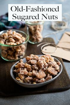 old - fashioned sugared nuts in small glass bowls on a wooden cutting board with the words, old - fashioned sugared nuts