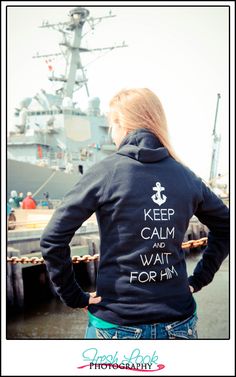 a woman standing in front of a ship wearing a hoodie that says keep calm and wait for him