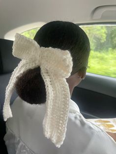 a woman in a car with a white scarf on her head