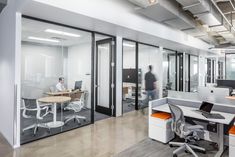 an office with glass walls and white desks