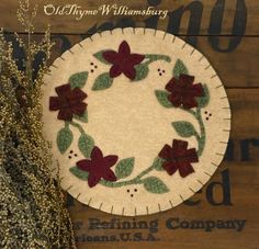 a christmas wreath with poinsettis on it sitting next to some dried grass