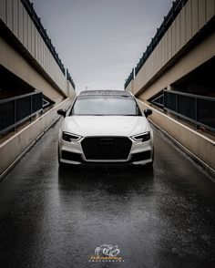 a white car is parked in the rain