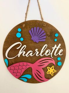 a wooden sign that says charlotte with an image of a fish and starfish on it