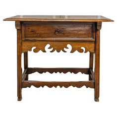 An Italian walnut side table from the 18th century with single drawer, carved apron and petite hoof feet. Born in Italy during the 18th century, this exquisite walnut side table exudes timeless elegance and meticulous craftsmanship. The rectangular top features beveled edges, adding a touch of refinement to the table's overall design. Below the top, a single drawer is adorned with an oval brass pull, providing both functionality and a subtle decorative accent. The carved apron adds a layer of de Walnut Side Table, Font Simple, Italian Side, Walnut Side Tables, Beveled Edge, Four Legged, Table Furniture, 18th Century, Timeless Elegance