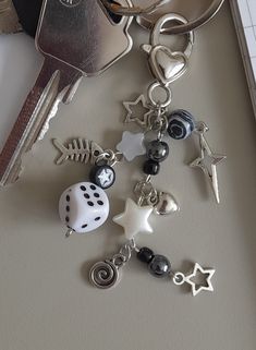 a bunch of keys that are on top of a keychain with some charms attached to it