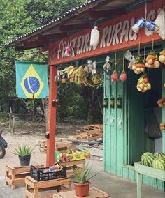 an outdoor market with fruit hanging from the roof