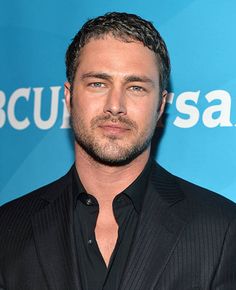 a close up of a person in a suit and tie with a blue background behind him