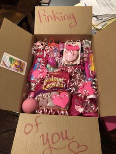 a box filled with candy and pinkies on top of a table