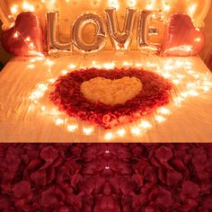 a bed covered in red flowers and lights with the word love spelled out on it