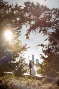 a bride and groom standing in front of the city skyline