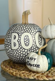 two pumpkins sitting on top of a wicker tray with boo happy halloween written on them