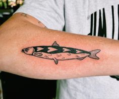 a man's arm with a fish tattoo on it