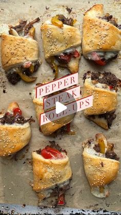 several mini sandwiches with peppers and steak in them on a baking sheet covered in wax paper