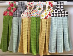 several different colored ties hanging on a white rack in front of a stove top oven