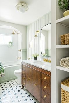 a bathroom with white walls and wooden cabinets