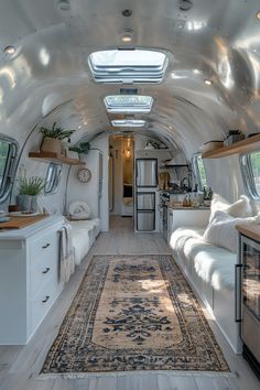 the interior of an airstream with lots of windows and white furniture, including a rug