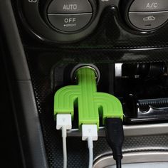 an electric car charger plugged in to the dash board with two usbs